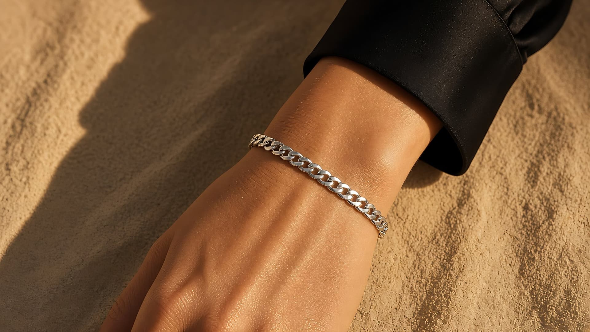 Wrist wearing a platinum curb chain bracelet