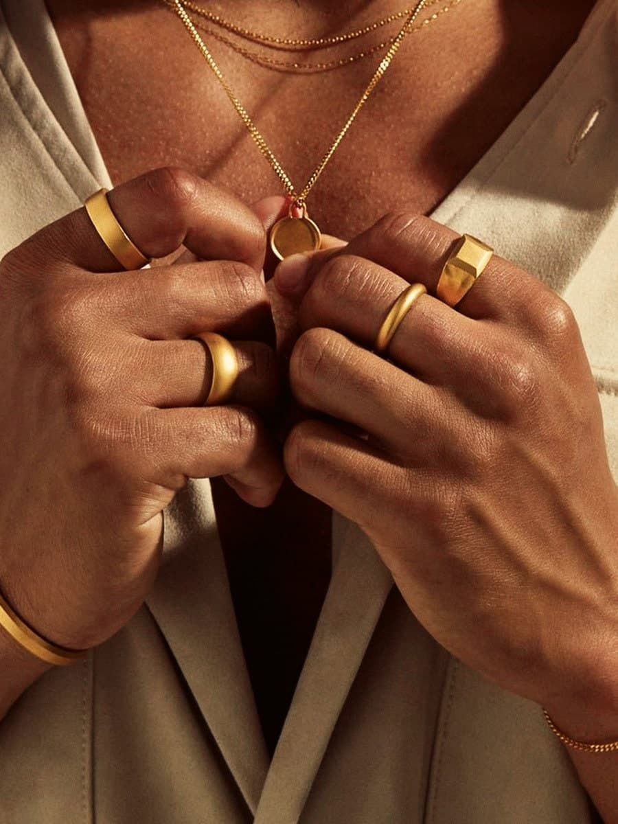 Model wearing the 24ct Gold Coin Pendant with stacked gold rings and bangles