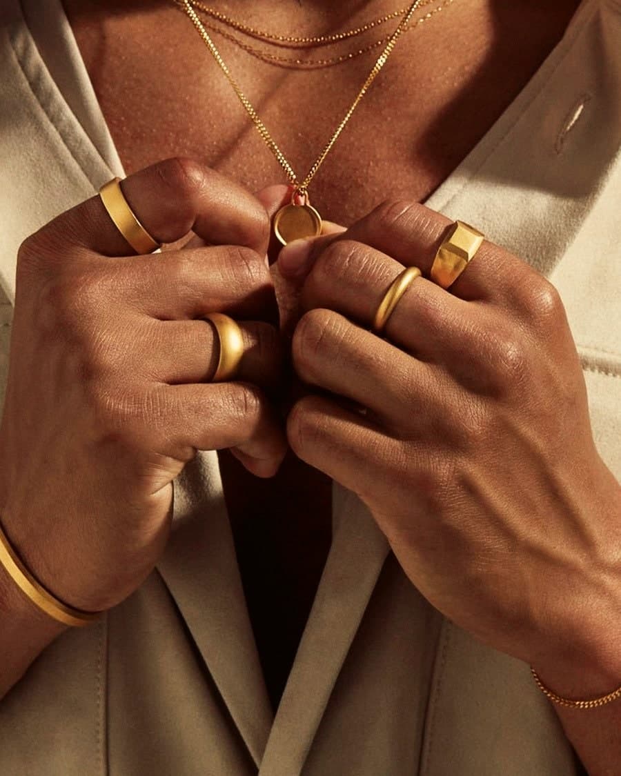 Model wearing the 24ct Gold Coin Pendant with stacked gold rings and bangles